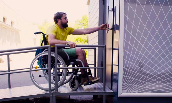 Молодий чоловік в інвалідному візку йде до громадського туалету — стокове фото