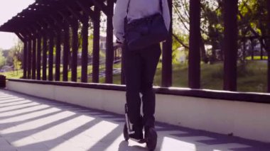 Bir tekme scooter sürme iş elbiseli bir adam