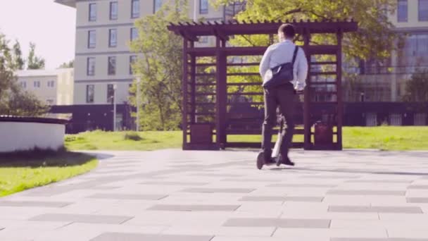 A man in a business suit riding a kick scooter — Stock Video