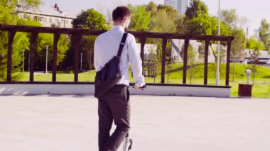 Tekme scooter'a binen bir adam.
