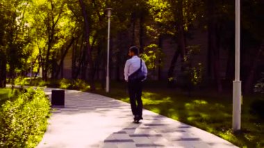 Bir tekme scooter sürme iş elbiseli bir adam