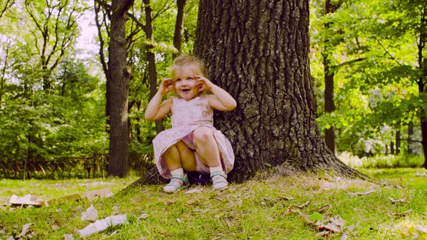 公園の芝生の上で座っている女の子 ロイヤリティフリーのストック写真