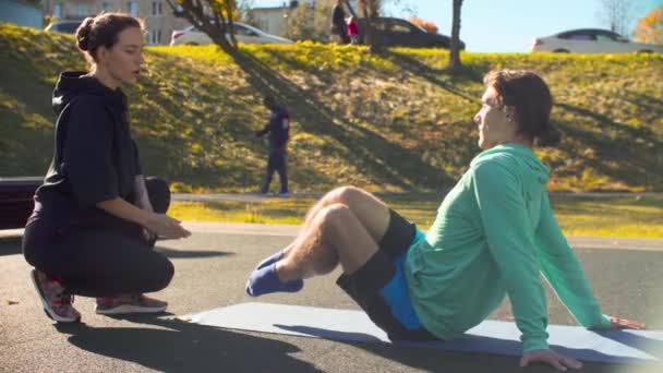 Молодой гибкий человек делает упражнения для прессы — стоковое видео