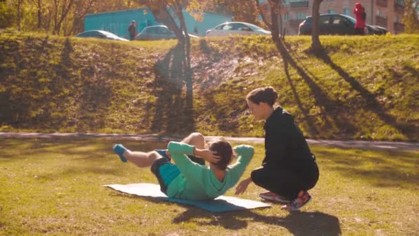 Ung flexibel man gör koreografi övningar på gräset — Stockvideo