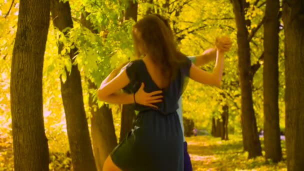 Jeune couple heureux dansant dans le parc d'automne 