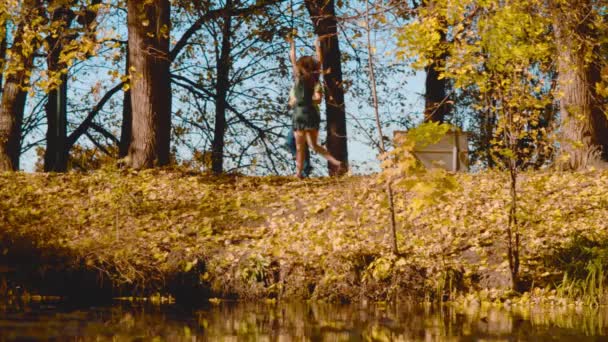 Unga lyckliga paret dansar på stranden av sjön — Stockvideo