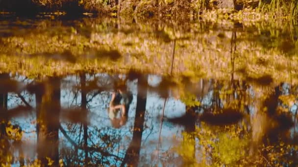 Young happy couple dancing on the bank of the lake — Stock Video