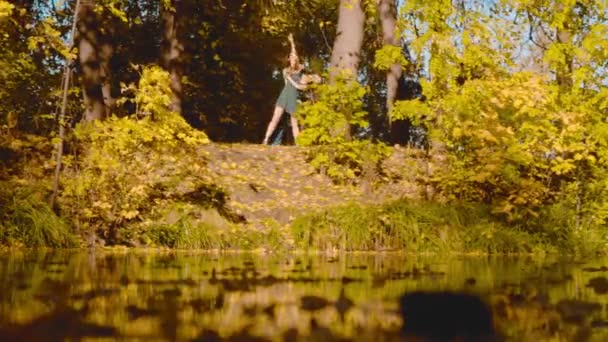 Joven pareja feliz bailando en la orilla del lago — Vídeo de stock