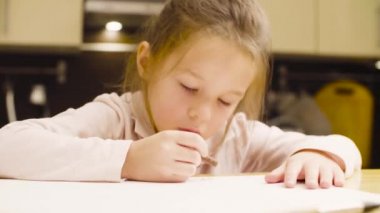 Bir kız bir masada kağıt üzerine pastel boya kalemi çizim