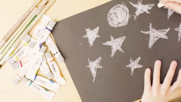 Ένα κορίτσι σχέδιο κραγιόνια παστέλ σε χαρτί σε ένα τραπέζι σε ένα δωμάτιο — Αρχείο Βίντεο