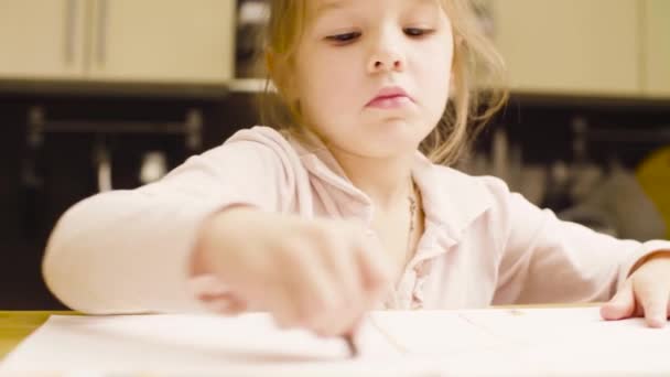 Bir kız bir masada kağıt üzerine pastel boya kalemi çizim — Stok video