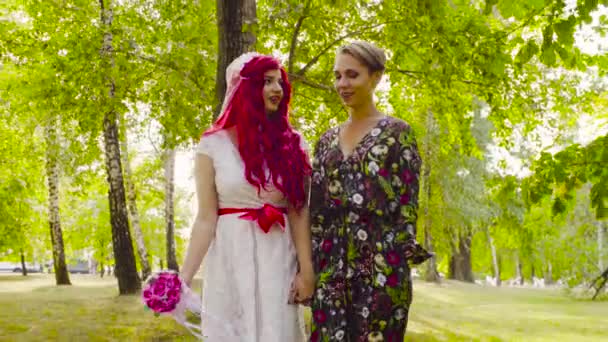 Leszbikus esküvő. A menyasszony és a vőlegény séta a parkban — Stock videók