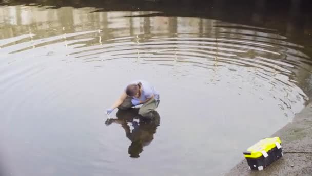 Vrouw ecoloog meten van ph van het water in de rivier van de stad. — Stockvideo