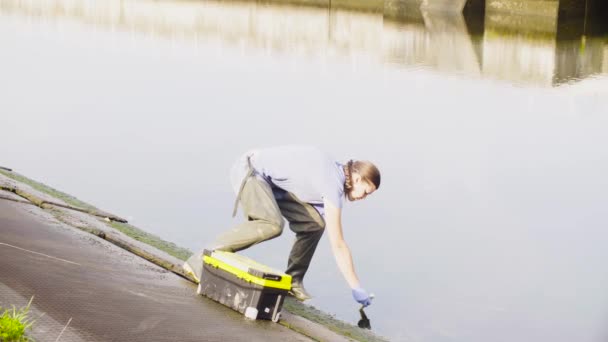 Mujer ecologista midiendo pH del agua en el río de la ciudad . — Vídeos de Stock