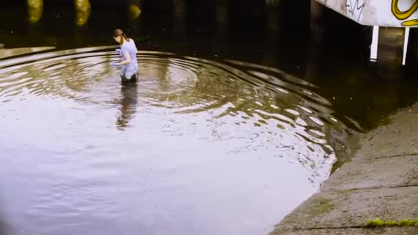 Ecologista obtendo amostras de plantas no rio da cidade — Vídeo de Stock