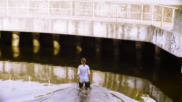 Ecologist getting samples of plants in the city river — Stock Video