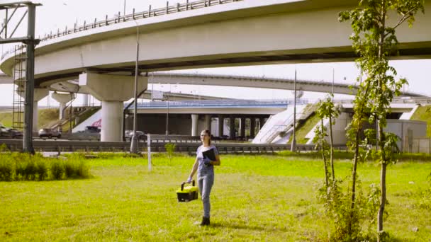 在高速公路附近写东西的妇女生态学家 — 图库视频影像