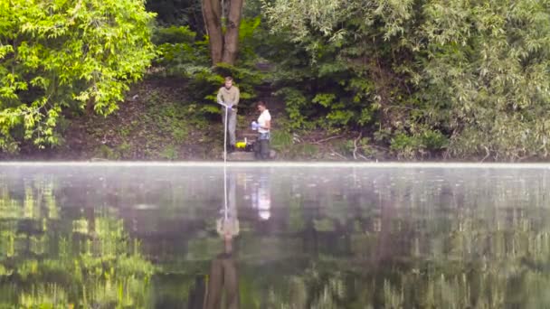 Dois ecologistas obtendo amostras de solo do fundo do lago — Vídeo de Stock