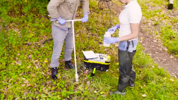 Два эколога получают образцы почвы в городском парке — стоковое видео