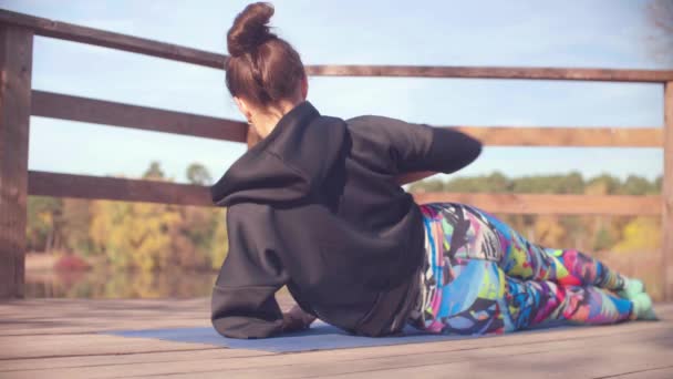 Femme faisant des exercices chorégraphiques sur le pont dans le parc — Video
