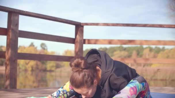 Mujer haciendo ejercicios coreográficos en el puente en el parque — Vídeo de stock