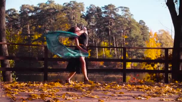 Een vrouw met een stal in haar handen op de brug alleen dansen — Stockvideo