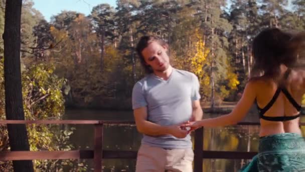 Ζευγάρι που χορεύει πάνω στην ξύλινη γέφυρα το φθινόπωρο — Αρχείο Βίντεο