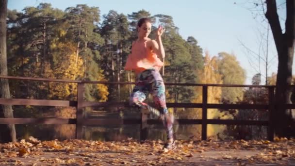 Mladá atraktivní žena tančí na mostě sám — Stock video