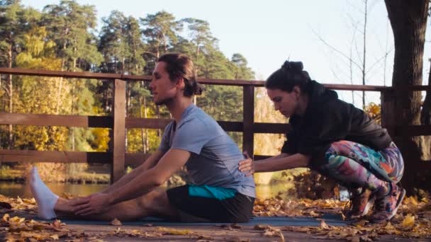 Vrouw doet stretching oefeningen voor een man — Stockvideo