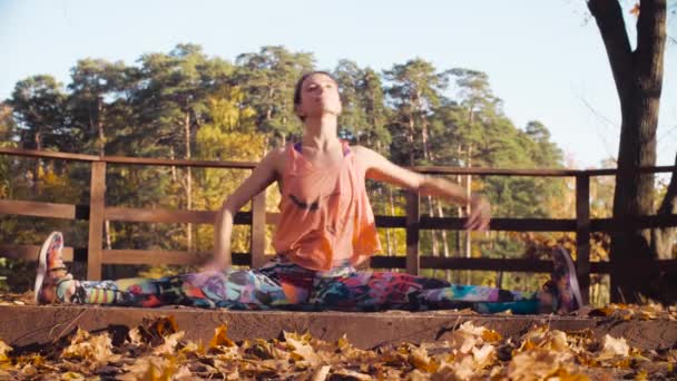 Vrouw doen choreografische oefeningen op de brug in het park — Stockvideo