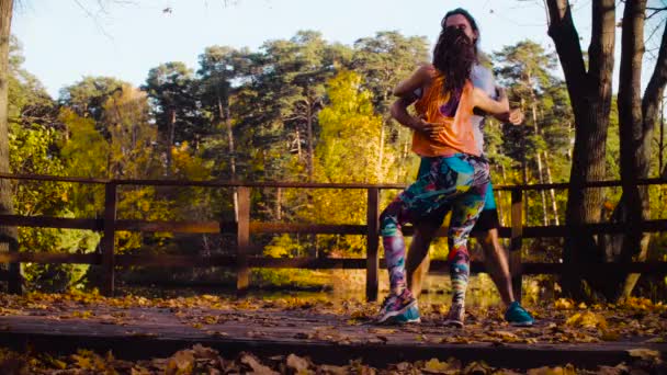 Pareja bailando en el puente de madera en otoño — Vídeo de stock