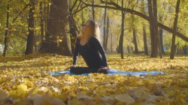 Genç çekici kadının Yoga exersices Park yapması