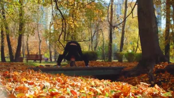 Jonge aantrekkelijke vrouw doen yoga oefeningen in het park — Stockvideo