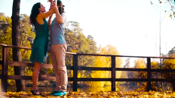 Young happy couple dancing on the wooden bridge — Stock Video