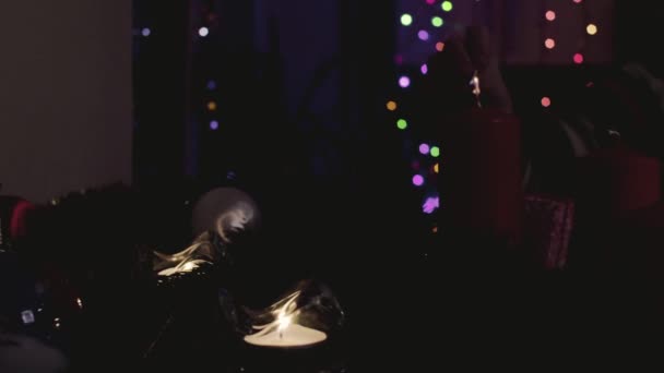 Female hands lighting candles in dark room — Stock Video