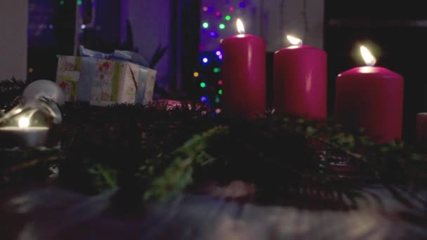 Regalo di Natale, candele accese e ghirlanda in una stanza buia — Video Stock