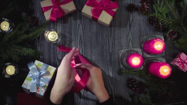Weibliche Hände binden Geschenke zur Feier des neuen Jahres — Stockvideo