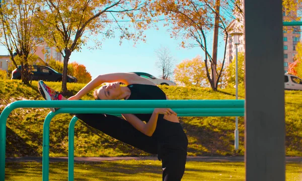 Mujer atractiva joven haciendo ejercicios en barras paralelas — Foto de Stock
