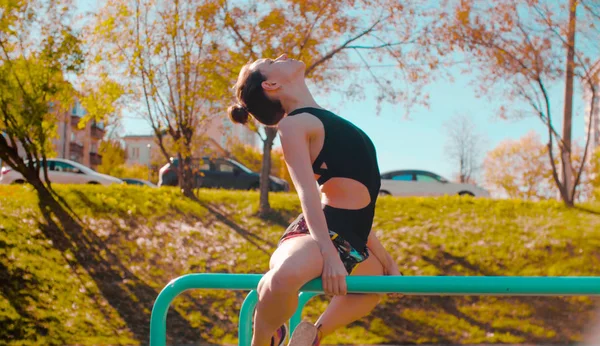 Jovem mulher atraente fazendo exercícios em barras paralelas — Fotografia de Stock