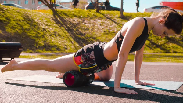 Mulher fazendo auto massagem das pernas com um rolo — Fotografia de Stock