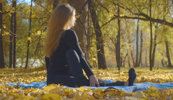 Jeune femme attrayante faisant des exercices de yoga dans le parc — Photo