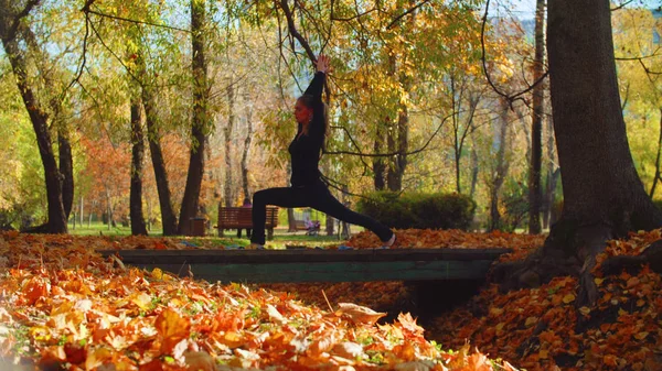 Jeune femme attrayante faisant des exercices de yoga dans le parc — Photo