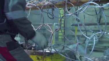 Tanınmayan işçi fabrikada metal net üreten