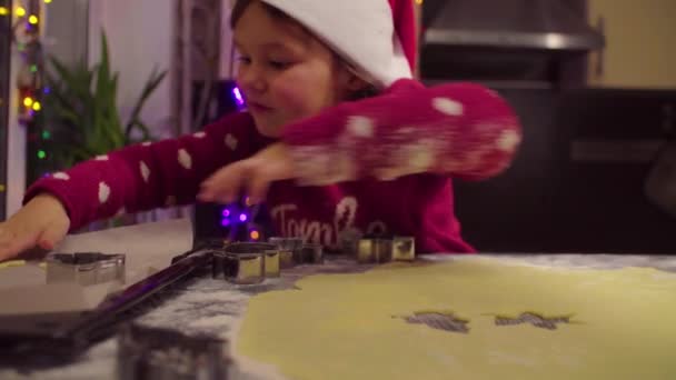 Mała dziewczynka rzeźbi ciasteczka świąteczne — Wideo stockowe