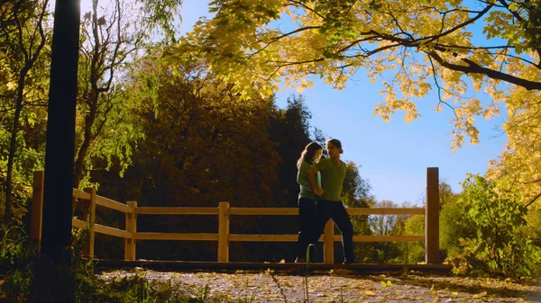 Молодая пара танцует на мосту в парке — стоковое фото