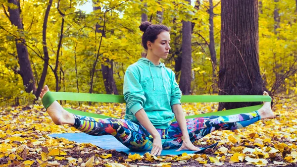 Young beautiful woman doing choreographic exercises in autumn forest — Stock Photo, Image