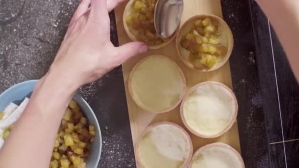 Händerna på en konditor ibruktagande apple flamberade tartlets — Stockvideo