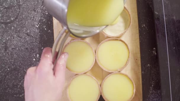 Bovenaanzicht Handen Van Een Banketbakker Gieten Lemon Curd Tartlets Close — Stockvideo