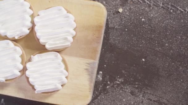 Hands of a confectioner burning swiss meringue on tartlets — Stock Video