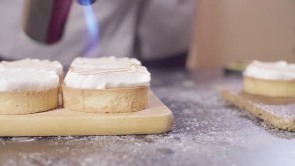 Hands of a confectioner burning swiss meringue on tartlets — Stock Footage Hands of a confectioner burning swiss meringue on tartlets Video Clip